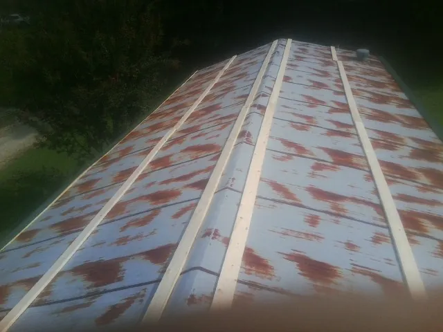 Rusted metal roof panels with new wood purlins before replacement — Storm Damage Roof Repair in Leakey by Roofing Brothers