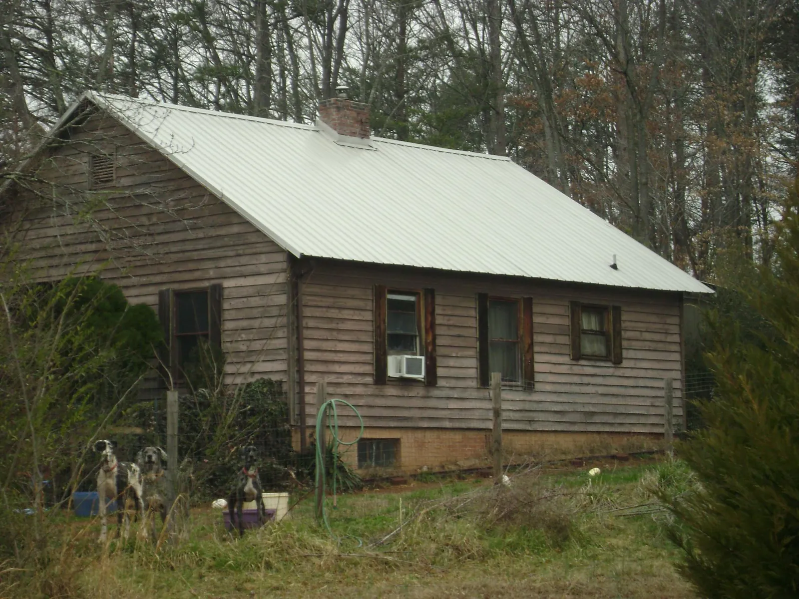 White metal roof on an old wood sided farmhouse, from a Metal Roof Installation job in Leakey